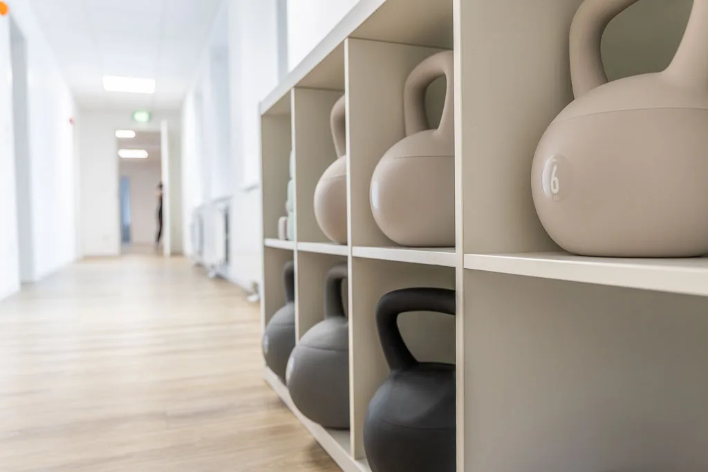 Regal mit Kettlebells, dahinter der Praxisflur
