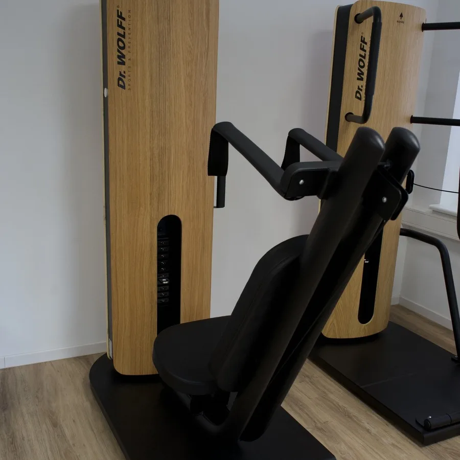 Zwei Kraftgeräte mit Holzverkleidung auf der Trainingsfläche des Therapiezentrums Barop