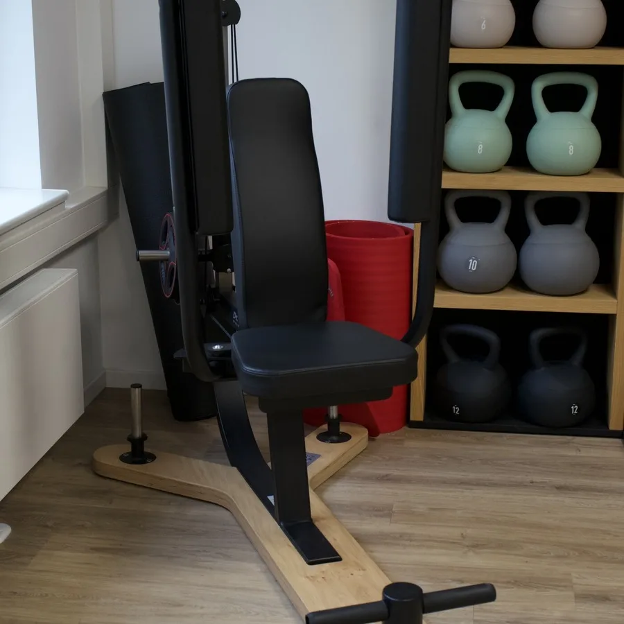 Regal mit Kettlebells in verschiedenen Gewichten neben einem Trainingsgerät
