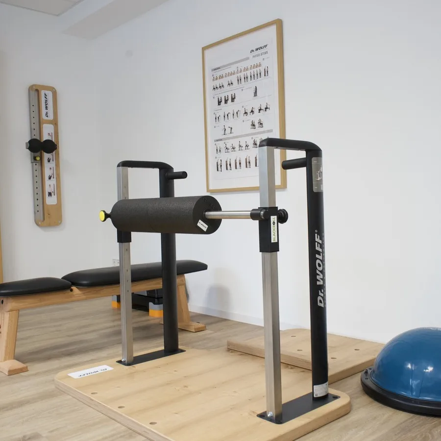 Trainingsstation mit Polsterrolle und Balancekissen auf einem Holzpodest
